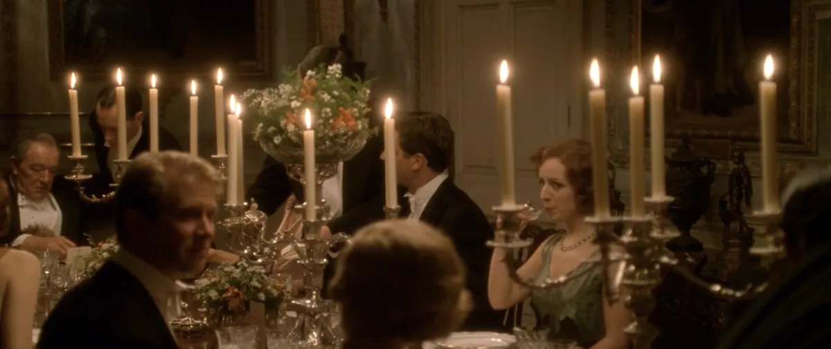 Guests and servants around a candlelit dinner table in Gosford Park (2001).