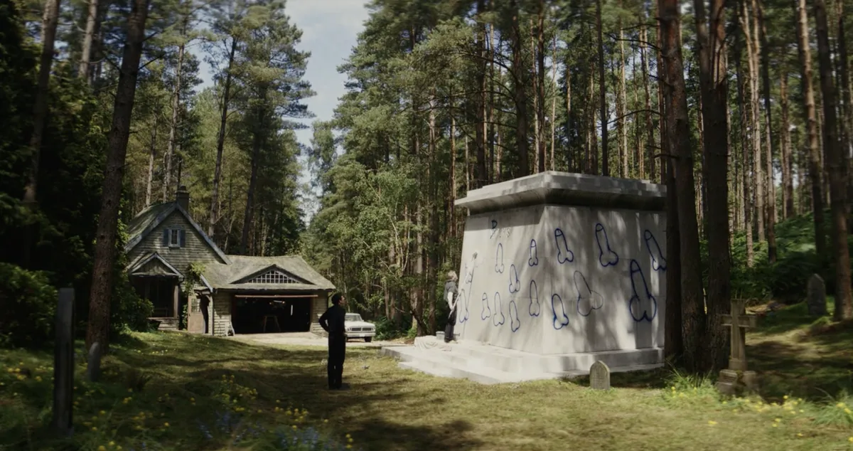 A wooded churchyard with a small mausoleum in Wake Up Dead Man (2025).